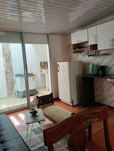 a small kitchen with a refrigerator and a table at Apartamento Victoria B in Ríohacha +35 photos
