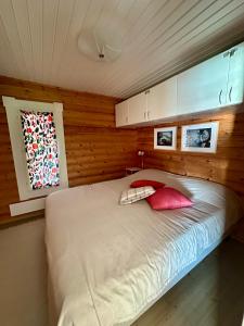 a bedroom with a bed with two pillows and a window at Kesäpesä in Artjärvi +17 photos
