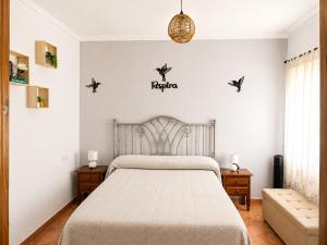 a bedroom with a bed with birds on the wall at Los Meri in Grazalema