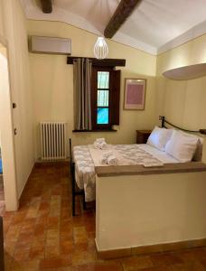 a bedroom with a bed and a table and a window at Le Case Gialle Resort in Gualdo Cattaneo