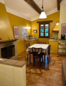 a kitchen with a table and chairs and a fireplace at Le Case Gialle Resort in Gualdo Cattaneo