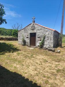 an old stone church with a cross on top at Casa Pancha in Cerdeda +4 photos