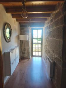 an empty room with a stone wall and a window at Casa Pancha in Cerdeda