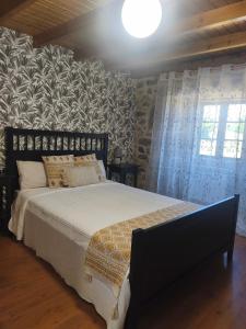 a bedroom with a bed in a room with a stone wall at Casa Pancha in Cerdeda