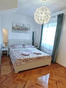 a bedroom with a bed and a chandelier at Sun house in Krk