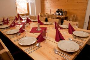 a long wooden table with plates and napkins and wine glasses at Penzion U Strakatého Koně in Blansko