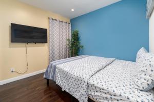 a bedroom with a bed and a flat screen tv at SF City Inn free parking on site in Oakland
