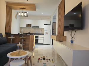 a living room and kitchen with a couch and a table at Nading flat in 'Aïn Benian +8 photos