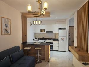 a kitchen and a living room with a couch and a table at Nading flat in 'Aïn Benian