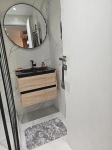 a bathroom with a sink and a mirror at Nading flat in 'Aïn Benian
