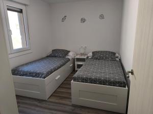 a bedroom with two beds and a window at VuT El Mirlo in Frías