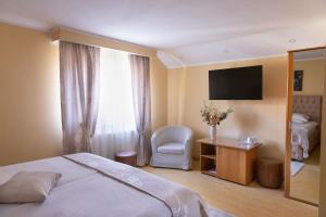 a hotel room with a bed and a television at Pension Tui in Sinaia