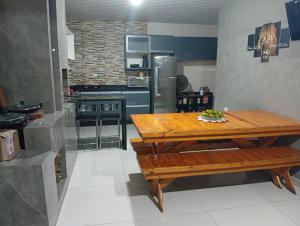 a kitchen with a wooden table and a refrigerator at Quarto em edícula com banheiro espaço privativo in Foz do Iguaçu
