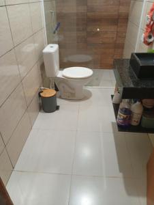 a bathroom with a toilet and a tiled floor at Quarto em edícula com banheiro espaço privativo in Foz do Iguaçu