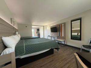 a bedroom with a large bed with a green comforter at Crescent Inn in Wilmington