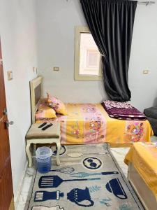 a room with two beds and a table and a window at Vrtn home in Al Ghuşnah