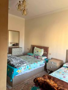 a bedroom with two twin beds and a mirror at Vrtn home in Al Ghuşnah