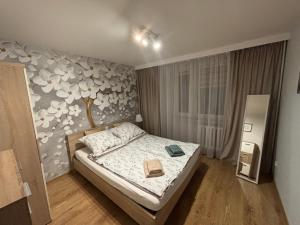 a bedroom with a bed with a flower patterned wall at Biała Centrum 2 in Biała Podlaska