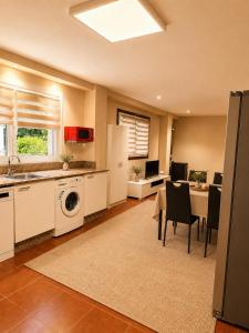 a kitchen with a sink and a table with chairs at Casa con piscina y jacuzzi in Pontevedra