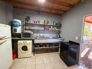 a kitchen with a sink and a washing machine at Alojamiento Matheo in El Soberbio