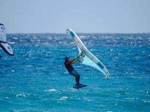 a man is windsurfing in the ocean on the water at Sea-view Apartment in Christ Church