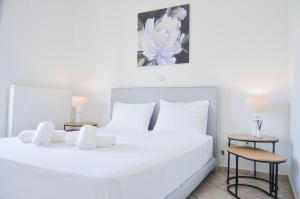 a bedroom with a large white bed with two tables at Angie's Serenity Apartment in Vathí