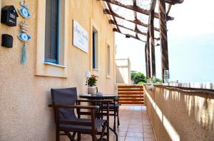 a patio with chairs and a table on a building at Angie's Serenity Apartment in Vathí