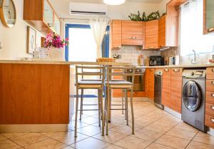 a kitchen with wooden cabinets and a counter with stools at Angie's Serenity Apartment in Vathí