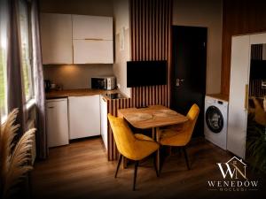a small kitchen with a table and chairs in it at 205 Wenedow Noclegi in Koszalin