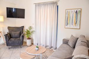 a living room with a couch and a chair and a table at Angie's Serenity Apartment in Vathí