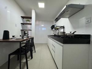 a kitchen with a counter and a table with chairs at M e M executivo in Ipatinga +5 photos