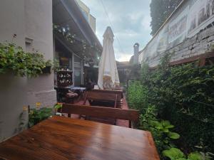 a patio with two wooden benches and an umbrella at Rooms&Rest ПИРОЋЋ Heritage in Pirot