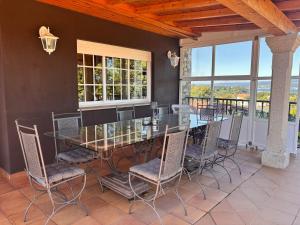a dining room with a glass table and chairs at Cumbre- chalet con piscina cubierta y vistas al mar en Sada in Sada