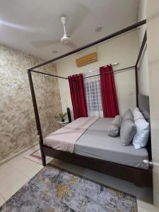 a bedroom with a canopy bed with red curtains at Ctr Ruby homestay in Shah Alam