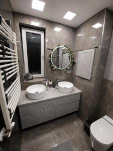 a bathroom with a sink and a mirror and a toilet at Bytča Central Apartment in Bytca +6 photos