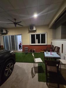a living room with a table and chairs and a fan at Ctr Ruby homestay in Shah Alam +2 photos