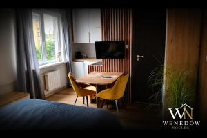 a small room with a table and chairs and a kitchen at 205 Wenedow Noclegi in Koszalin +2 photos
