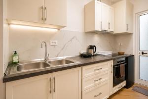 a kitchen with white cabinets and a sink at Villa Reve de Tirana in Tirana +40 photos