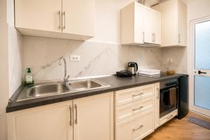 a kitchen with white cabinets and a sink at Villa Reve de Tirana in Tirana