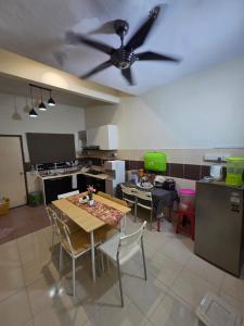 a kitchen with a table and a ceiling fan at Ctr Ruby homestay in Shah Alam