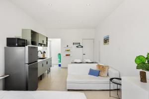 a white living room with a white couch and a kitchen at Villa Sirena Azul Apt 1 in Palm-Eagle Beach