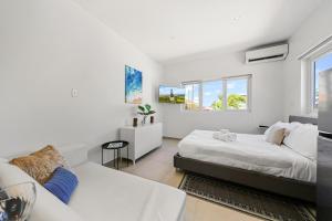 a white bedroom with a bed and a couch at Villa Sirena Azul Apt 1 in Palm-Eagle Beach