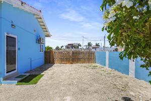 a blue house with a wooden fence next to it at Villa Sirena Azul Apt 1 in Palm-Eagle Beach