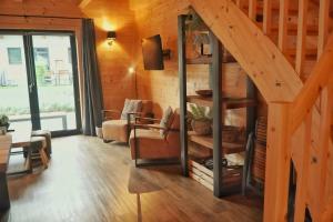a living room with a staircase in a wooden house at Nassfeld Holiday Home in Rattendorf