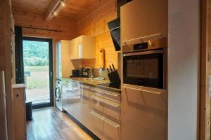 a kitchen with a sink and a microwave at Nassfeld Holiday Home in Rattendorf
