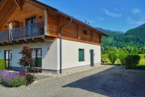 a house with a balcony on the side of it at Nassfeld Holiday Home in Rattendorf