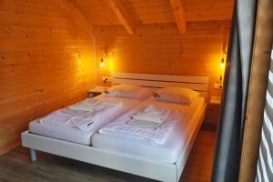 a bedroom with two beds in a wooden cabin at Nassfeld Holiday Home in Rattendorf