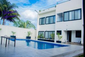 a house with a swimming pool next to a building at Valentinos Appartement Prestige in Agbodrafo
