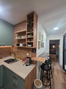 a kitchen with a counter and two bar stools at "Dolce Vita" Loft in Tuzla +10 photos