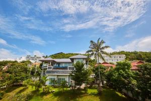 a house on a hill with palm trees at NB Villa Vimana in Bang Rak Beach